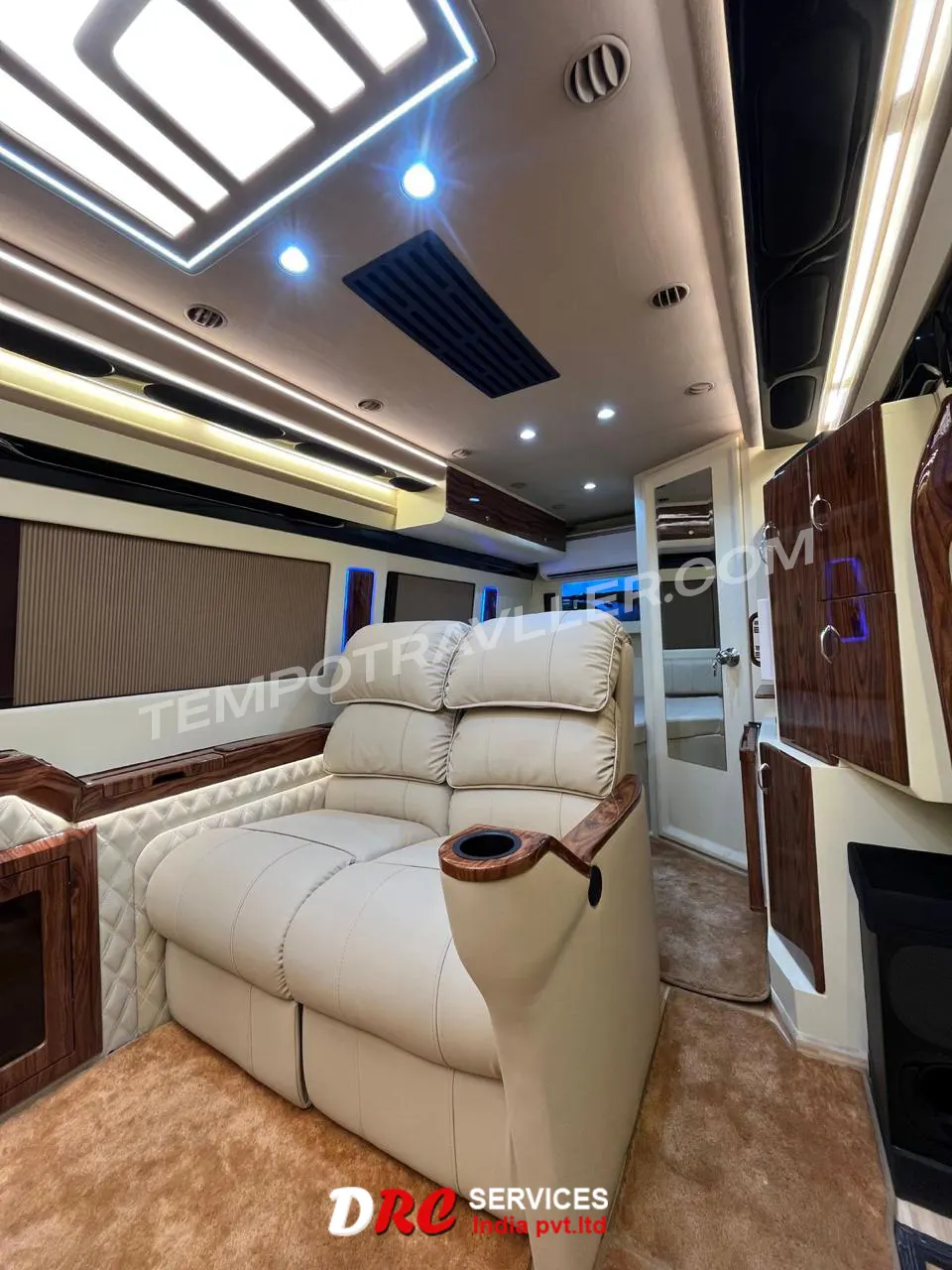 Luxury motorhome interior featuring premium recliner seats, wooden paneling, ambient ceiling lights, and modern design.